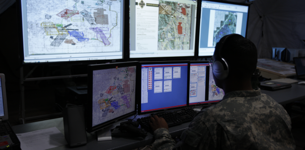 Intelligence soldier looking at multiple computer screens
