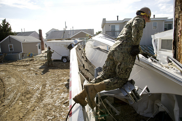 Image description: In Seaside Heights, New Jersey, Constructionman Collyn Schagenhauff of the Naval Mobile Construction Battalion 11 (U.S. Navy) attaches a cable to a speedboat that was flipped on its side by Hurricane Sandy.
Photo by U.S. Navy photo by Mass Communication Specialist 1st Class Martin Cuaron.