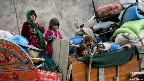 Afghan refugee children stand on their belonging loaded on a truck as they depart for Afghanistan at a UNHCR repatriation terminal near Quetta, Pakistan, Nov. 17, 2012. [AP File Photo]
