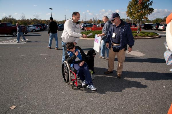 Flemington, N.J., October 22, 2011 -- Tony Rebinbas and his son get mitigation information from Bill Praust, a Community Relations specialist, as Tyak, a service dog, looks on. FEMA provides outreach for many programs offered to disaster survivors.