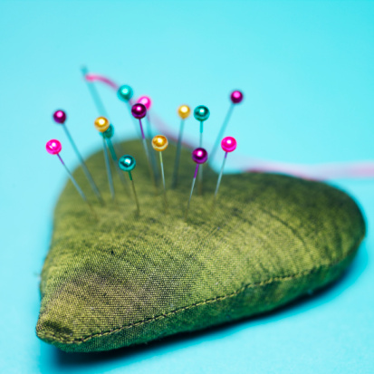 heart-shaped pin cushion with brightly colored pins