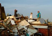 Dos mujeres hija revisan los daños ocasionados a su hogar después de que un tornado destruyera la vivienda