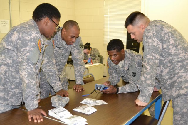 Army Reservists from the 1398th Deployment and Distribution Support Battalion train each other on container scanning equipment use while conducting a vessel offload exercise during the unit's mobilization training at Camp Shelby, Miss., 11-15 Jan. (Photo by Sarah Garner, Hq. Military Surface Deployment and Distribution Command)