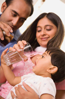 Parents giving their child a drinkof water