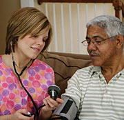 a nurse checking on patient's blood pressure