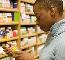Woman examining a pill bottle.