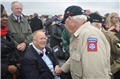 ABMC Secretary Max Cleland shakes hands with a D-Day veteran.