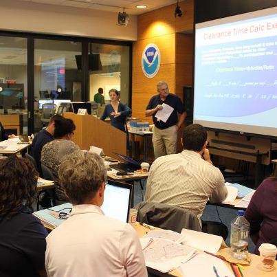 Photo: Training continues this week at NHC for two dozen emergency managers and decision-makers from the Southeast U.S. coastal community. It's a hands-on exercise today, with a hurricane threatening the Southeast U.S. coastline. In this photo, FEMA Region III's Dave Odegard and FEMA Region IV's Rebecca Jennings lead the class through the drill.