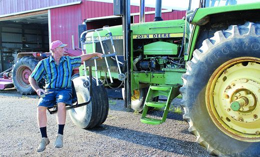 Indiana farmer Mark Hosier, paralyzed from the waist down, uses a mechanical lift to board his tractor.