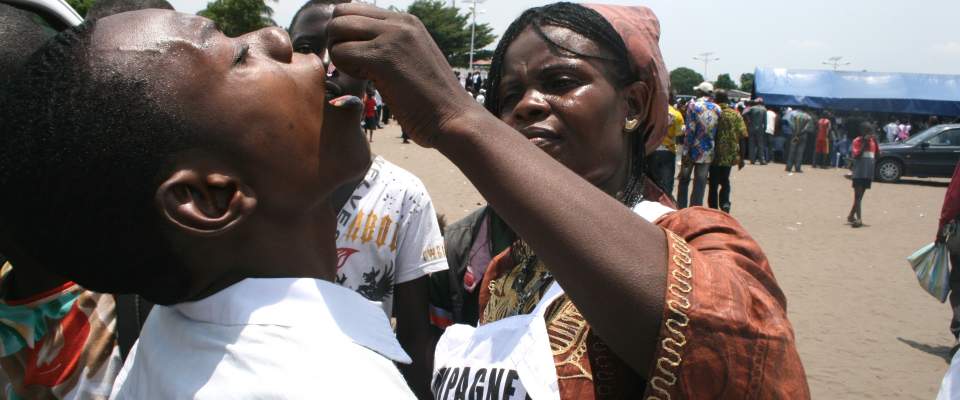 Global Health: A woman in the Democratic Republic of Congo (DRC) administers a polio vaccine March 23 in Commune de Ndjili, Kins