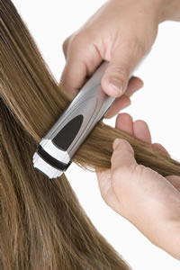 photo of a woman's hair being straightened