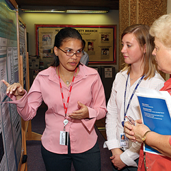 Three female colleagues conversating in front of the information board