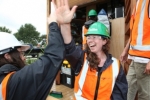 Amanda Crosby, right, and Belinda Dods of New Zealand celebrate placing the final screw on the deck of their house at Solar Decathlon 2011.