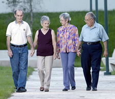 Dos parejas de personas de edad avanzada dando un paseo a pie para aliviar el estres