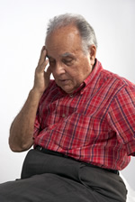Un hombre de edad avanzada estresado tocando su  cabeza con una mano