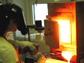 Photo of Amy Barnes making phosphorus-rich phosphate glass to use with her doctoral research work.