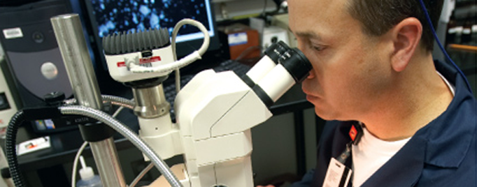 man looking into a microscope in a laboratory