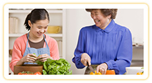 A grandmother and granddaughter having fun making dinner