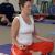 A woman practices a meditative yoga pose.