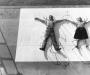 man and woman lying on their backs, "pinned" by chair bases