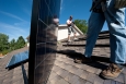 Brian Webster (left) and Mario Richard install photovoltaic modules on an Englewood, Colorado, home. | Photo by Dennis Schroeder, NREL. 