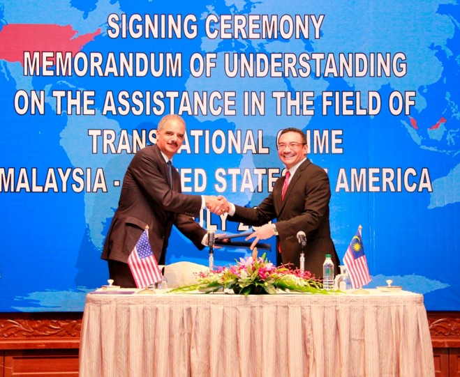 Attorney General Holder signs MoU with Malaysian Minister for Home Affairs Hishammuddin. Photo Credit: U.S. Embassy