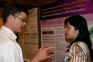 Alex Walley, Univ of Boston and Nhu To Nguyen, Vietnam speaking to each other in front of Dr. Nguyens poster presentation.