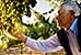 Welcome: Portraits of America, man examining grapes in vineyard