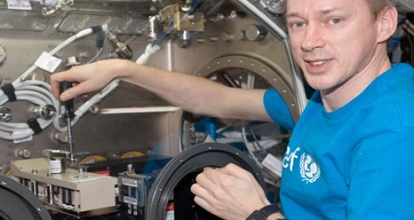 Astronaut Frank DeWinne works with the Selectable Optical Diagnostics Instrument Influence of Vibration on Diffusion in Liquids (SODI-IVIDIL) hardware in the Microgravity Science Glovebox (MSG) aboard the International Space Station. (Credit NASA)