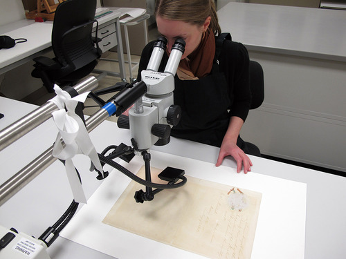 preservearchives:


Before preparing the Emancipation Proclamation for exhibition on its 150th anniversary, a senior conservator examines the signature page with a binocular microscope.  The Fifth Page clearly shows darkening of the paper from excessive light exposure.  Emancipation Proclamation, RG 11, ARC # 299998. 
