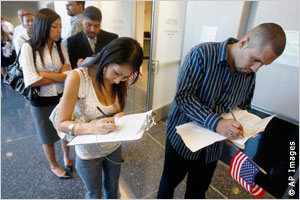 People standing in line, filling out forms (AP Images)