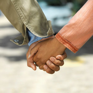 Photograph of two young people holding hands.