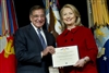 Secretary Panetta presents former Secretary Clinton with a medal