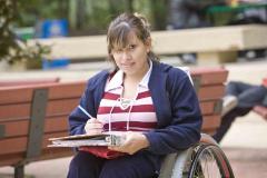 Girl with notebook in wheelchair