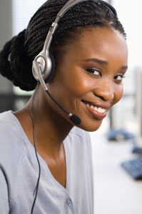 Photograph of a young woman wearing an audio headset and smiling.