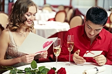 A couple reading Valentine's Day cards at a restaurant