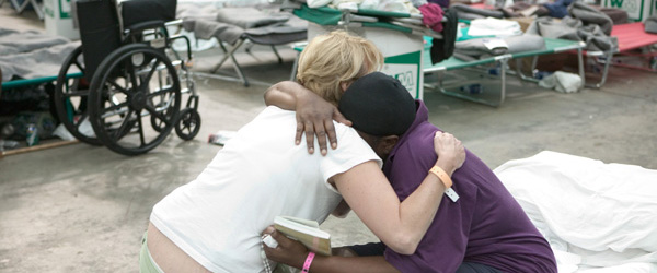 An aid worker comforts a Hurricane Katrina disaster victim.