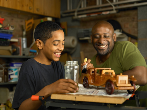 A photo of an African American mentor and a boy woodworking.