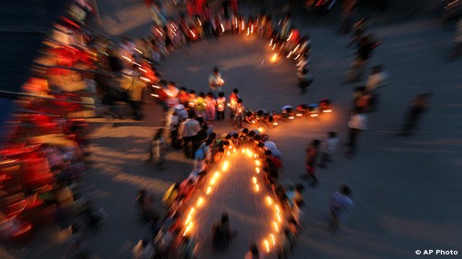 Children stand depicting the ribbon, the symbol of AIDS, during a candlelight rally to mark World AIDS Orphans' Day  in Gauhati, India, May 7, 2007. [AP File Photo]