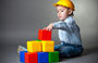 Child with hardhat and playing with building blocks