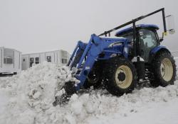 Heavy snow is cleared with a tractor from the Temporary Housing Unit staging area