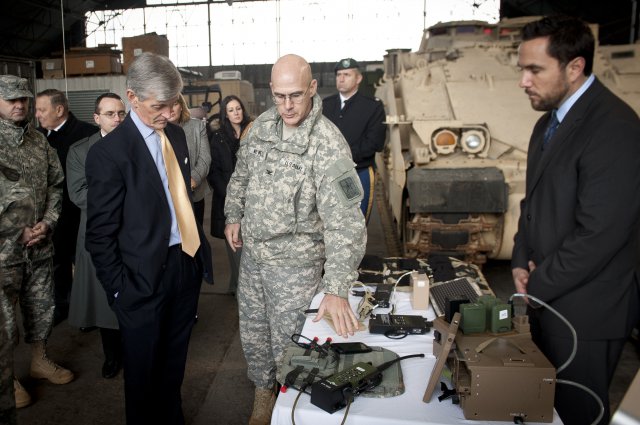 Col. Peter A. Newell, Rapid Equipping Force director, briefs Secretary of the Army John McHugh on the Energy to the Tactical Edge effort, which includes solar capabilities, hybrid generators and these universal battery chargers, Jan. 15, 2013, at Fort Belvoir, Va.