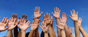 Photograph of diverse raised hands.