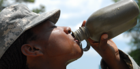 Basic Combat Training Soldier takes a drink from her canteen during a break