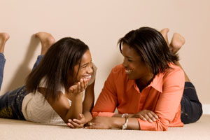 Photograph of two teen girls talking and smiling.