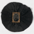 A black rosette with a picture of Lincoln in the middle.