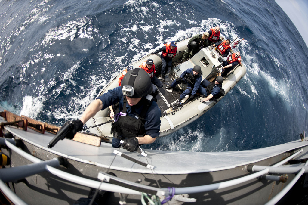 Image description: A U.S. Sailor with the visit, board, search and seizure team assigned to the USS Lassen boards a South Korean navy combat support ship during a training scenario in the East China Sea. The sailors conducted the mission with South Korean navy SEALs and an underwater demolition team members as part a trilateral interoperability exercise that included U.S., South Korean, and Japanese naval vessels.
Photo by U.S. Navy Mass Communication Specialist 3rd Class Paul Kelly