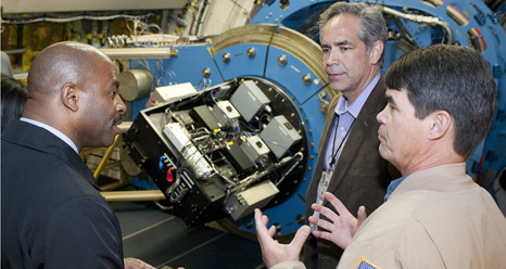 NASA Dryden electronics technician Jim Mills explains details of the High-speed Imaging Photometer for Occultation, or HIPO, mounted on the SOFIA observatory's infrared telescope to NASA education chief and former space shuttle astronaut Leland Melvin during his tour of the Dryden Aircraft Operation