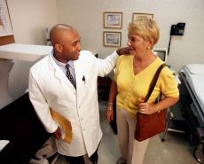 Photograph of a male doctor talking with a senior female patient