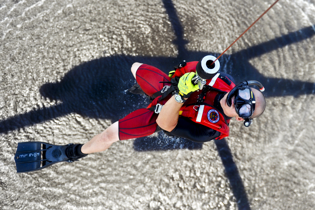 Image description: U.S. Coast Guard Petty Officer 1st Class Bret Fogle, a rescue swimmer, is hoisted into an MH-60 Jayhawk helicopter at Coast Guard Air Station Elizabeth City, N.C.
Photo by Petty Office 1st Class Brandyn Hill, U.S. Department of Defense.